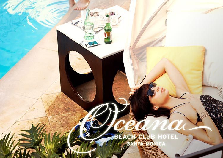 A brunette woman lounges poolside on a white chair. The Oceana Beach Club Hotel logo is in the lower right corner.