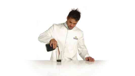 A chef in a white apron makes a cocktail using Patrón tequila.